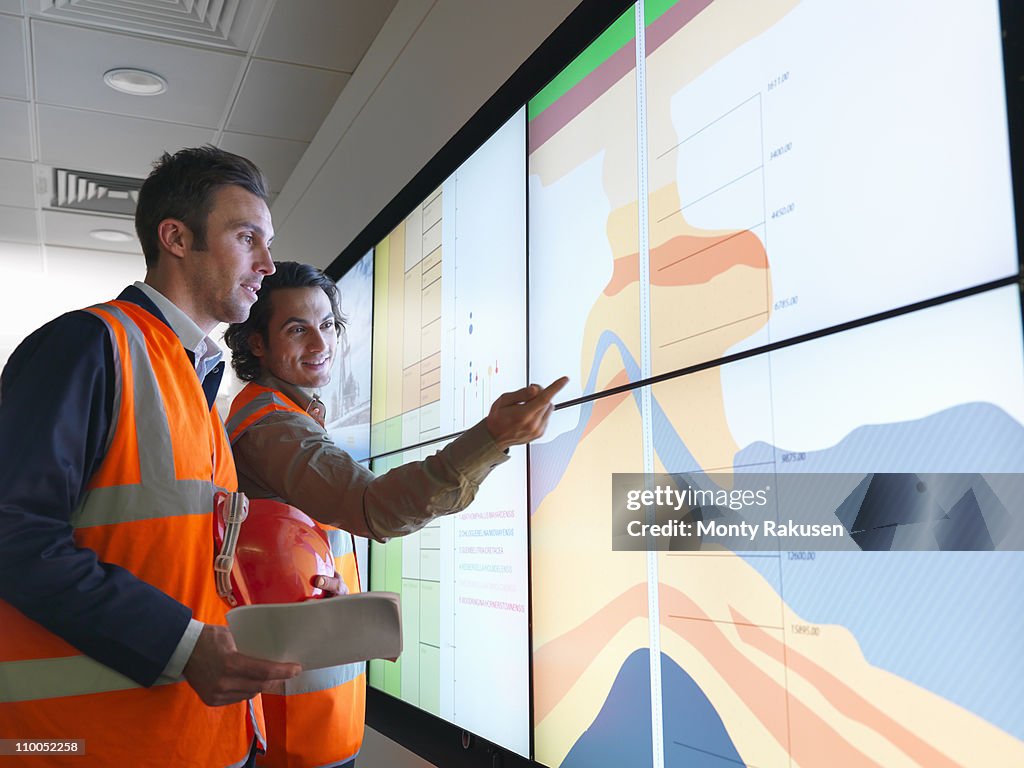 Oil workers with geology screen