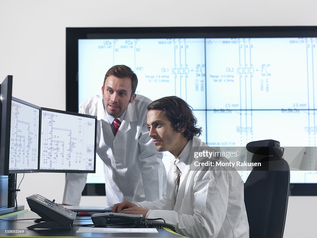 Scientists with diagrams on screens