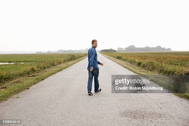 man on road - looking over shoulder photos et images de collection