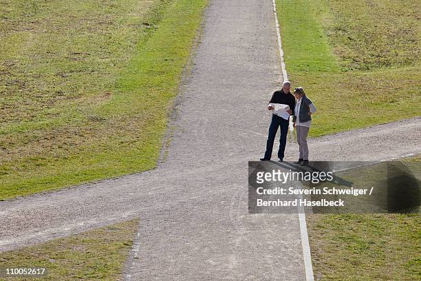 older couple with map at a crossroads - crossroad stock pictures, royalty-free photos & images