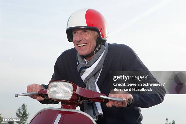 senior man on scooter - motorradhelm stock-fotos und bilder