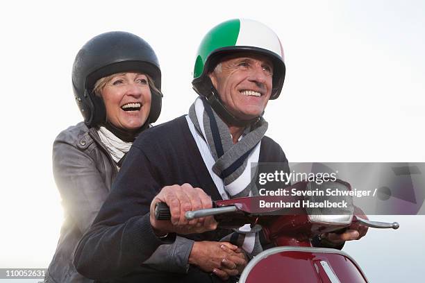 senior couple on scooter - baby boomer couple stock-fotos und bilder