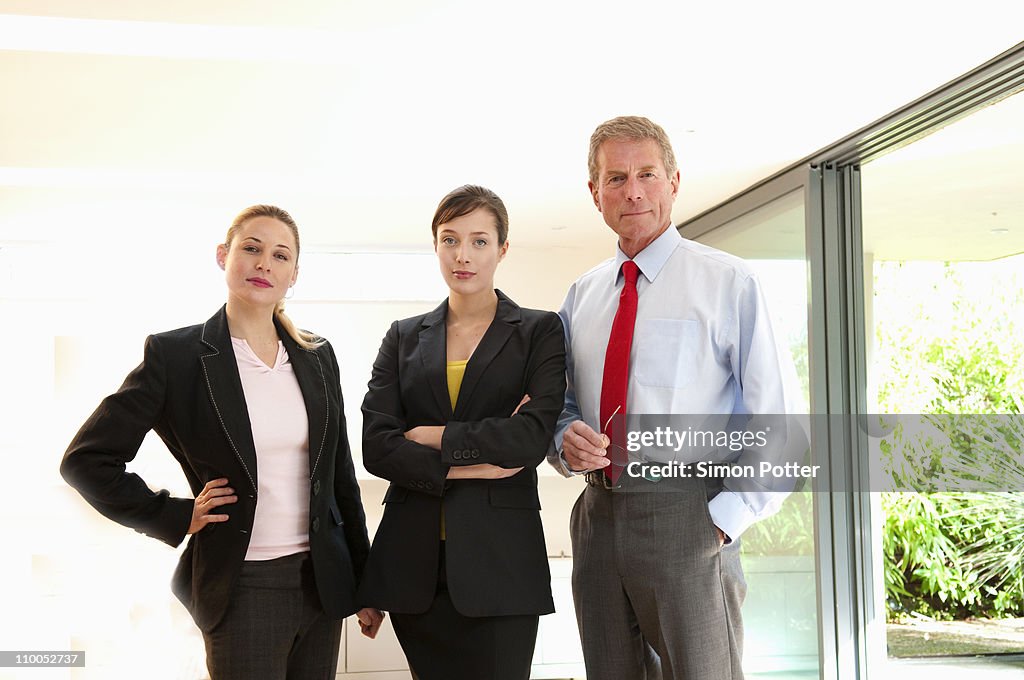 Confident business trio in light office