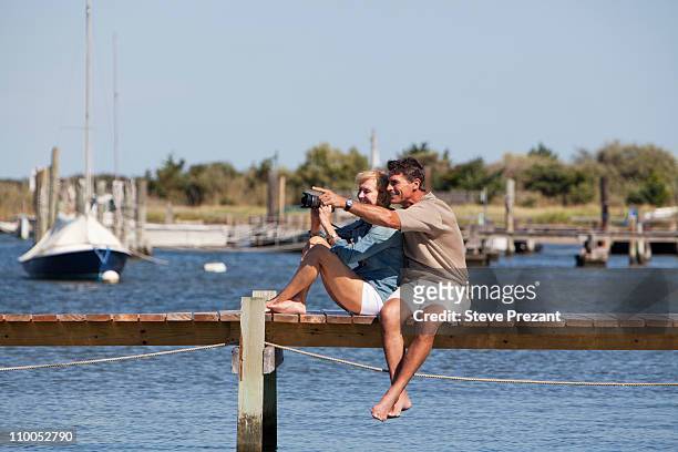 paar sitzt auf einem dock - insel long island stock-fotos und bilder