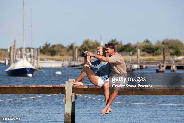 couple sitting on a dock - long island ny stock pictures, royalty-free photos & images
