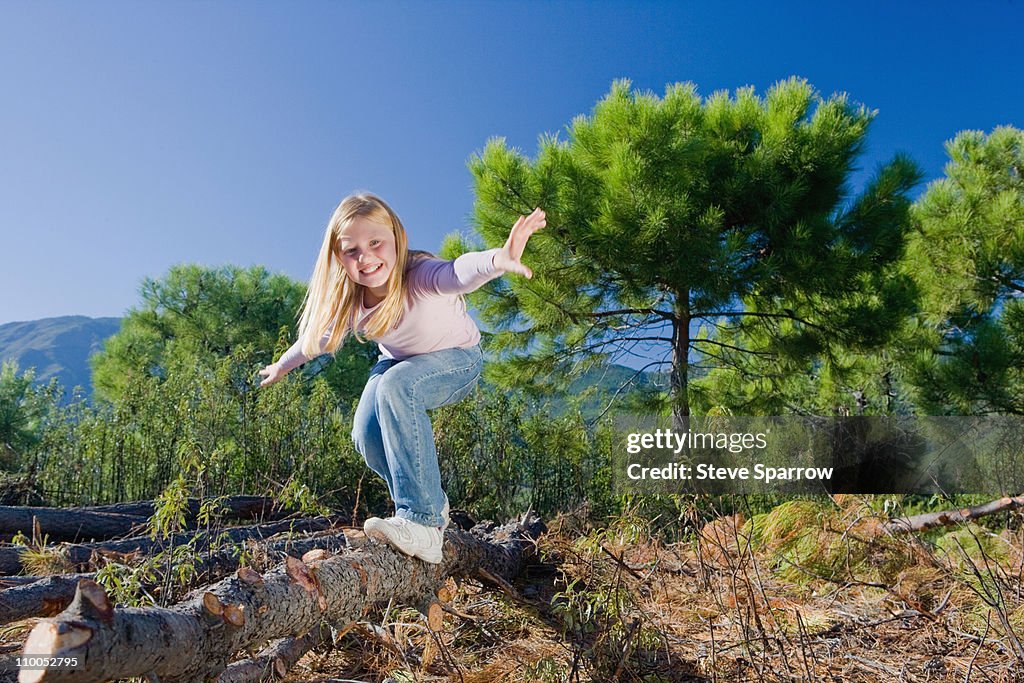 Young girl balancing/surfing on log