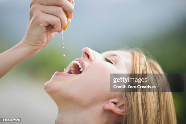 girl squashing orange - mouth open profile stock pictures, royalty-free photos & images