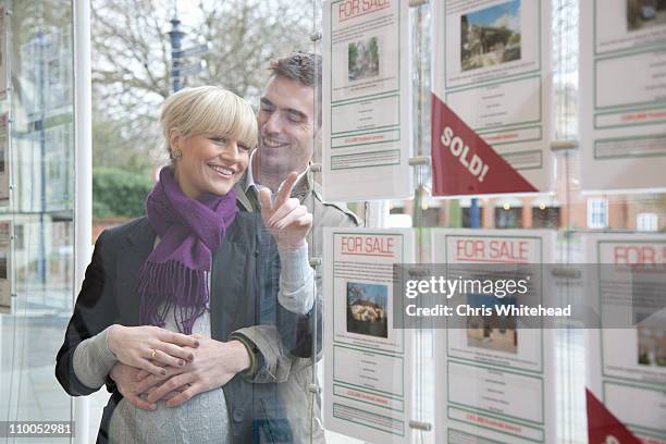 couple looking into estate agents window - hertfordshire stock-fotos und bilder