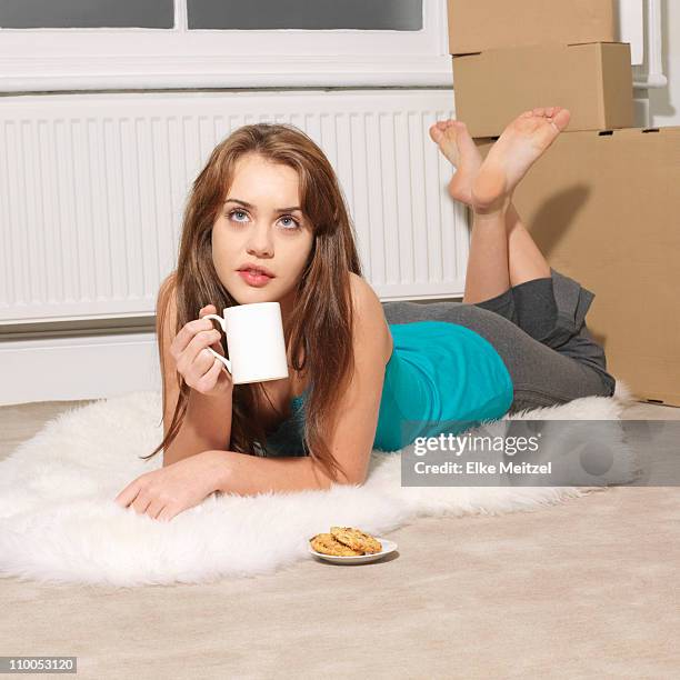 young woman lying down next to boxes - fur rug stock pictures, royalty-free photos & images