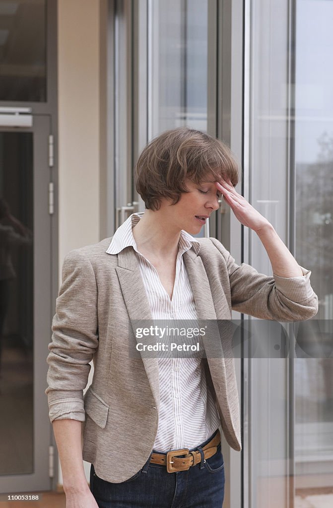 Business woman holding hand at forehead