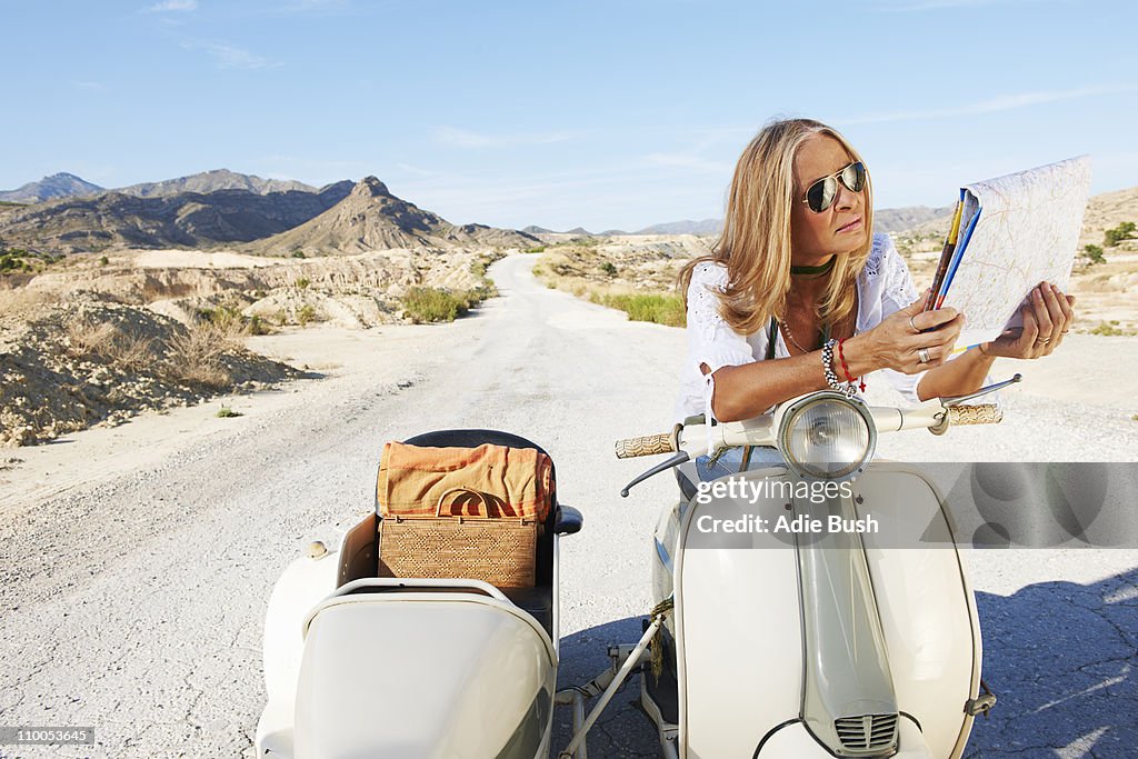 Woman Sitting on motorbike with map