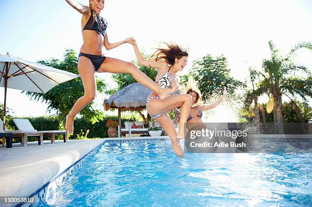 girls jumping into swimming pool - jump in pool stockfoto's en -beelden