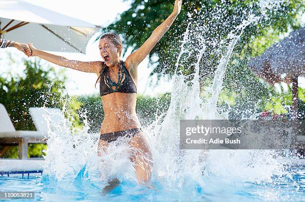 girl jumping into swimming pool - jump in pool stock-fotos und bilder
