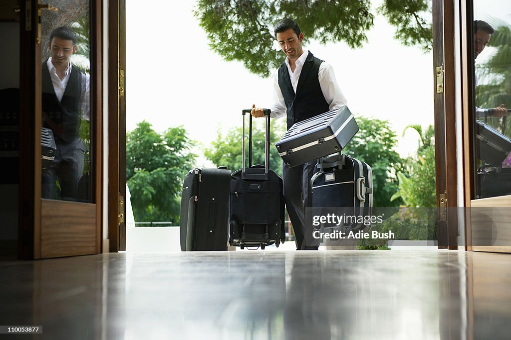 Man carrying suitcases into hotel