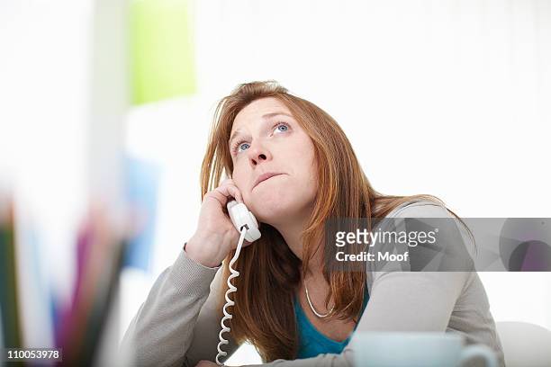 girl on the telephone sitting at desk - wait photos et images de collection