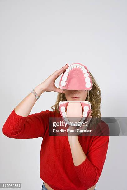 woman holding open model teeth - gebiss mensch zähne stock-fotos und bilder