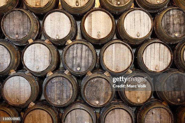 stacked oak barrels in a winery - tonneau photos et images de collection