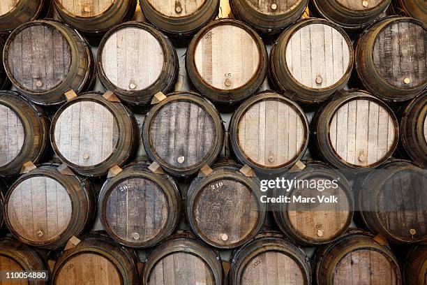 stacked oak barrels in a winery - barrels ストックフォトと画像