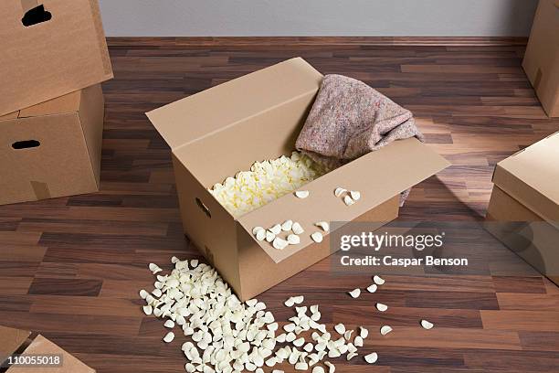 moving boxes, packing peanuts and a drop cloth - packing peanut stock pictures, royalty-free photos & images