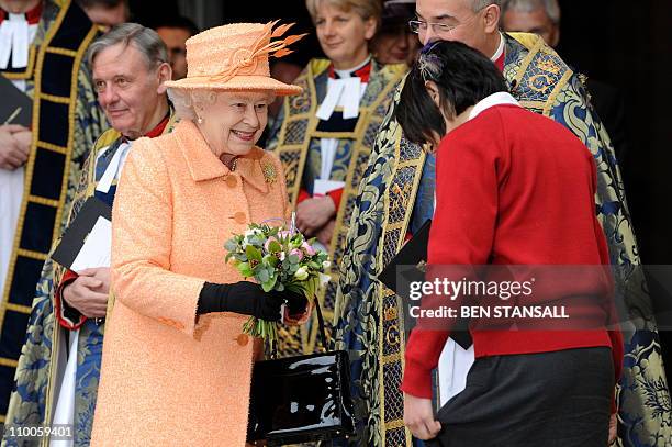 School girl gives Britain's Queen Elizabeth II flowers as she leaves after attending the annual Commonwealth Day Observance Service at Westminster...