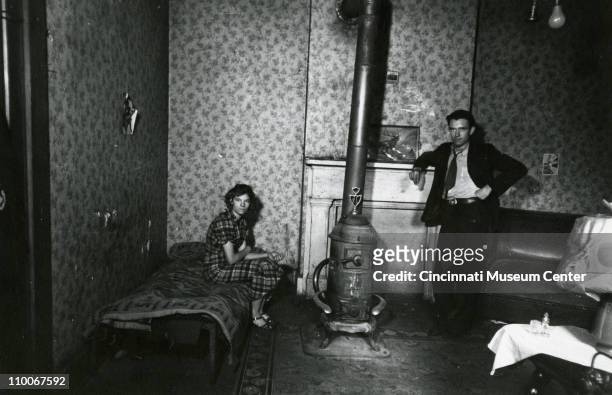 Portrait of a young couple as they pose in a bed and sitting room in West End, Cincinnati, Ohio, December 1935.