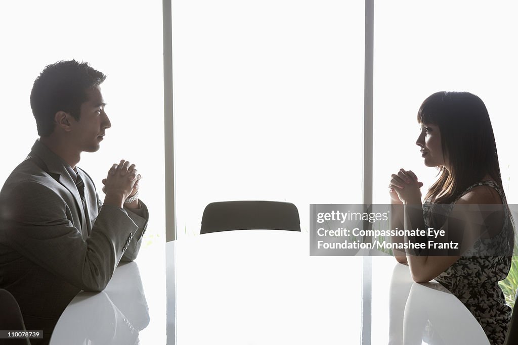 Man and woman on opposite sides of boardroom table