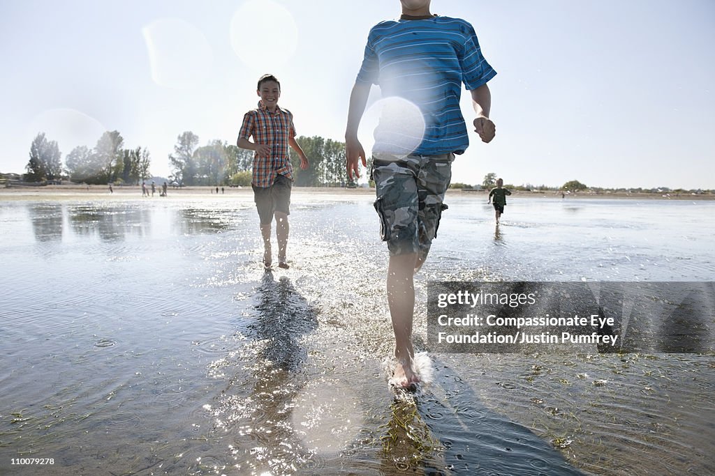 Young boys running and playing in the water