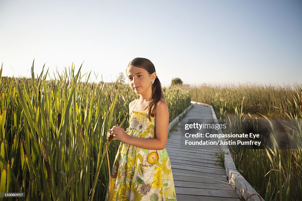 Girl on a path in a field of tall grass