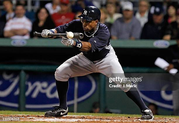 Outfielder Curtis Granderson of the New York Yankees bunts for a single against the Boston Red Sox during a Grapefruit League Spring Training Game at...