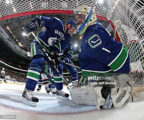 Roberto Luongo of the Vancouver Canucks stops the puck while teammate Dan Hamhuis of the Vancouver Canucks looks on during their game at Rogers Arena...