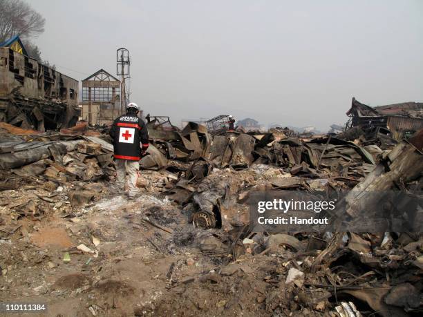 In this handout images provided by the International Federation of Red Cross Japan, A member of the Japanese Red Cross team walks through what is...