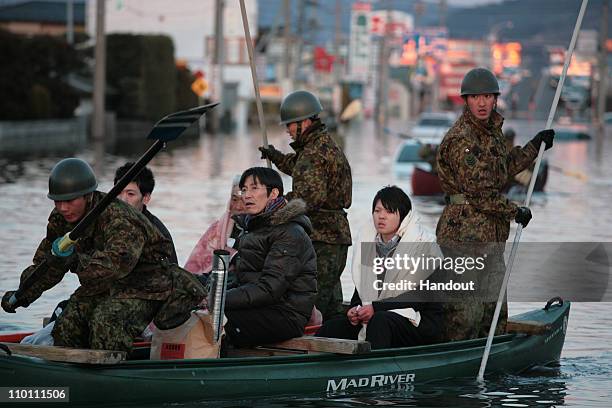 In this handout images provided by the International Federation of Red Cross Japan, The military are seen coordinating the transportation of those...