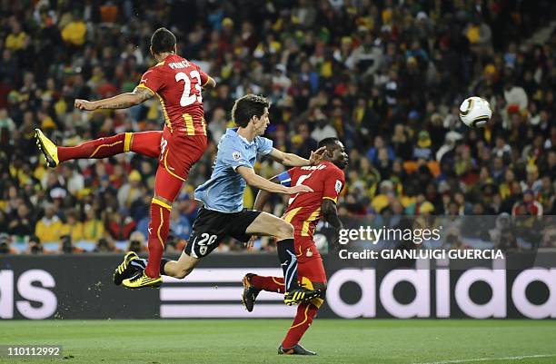 Ghana's striker Kevin-Prince Boateng heads the ball ahead of Uruguay's midfielder Alvaro Fernandez and Ghana's defender John Mensah during the 2010...