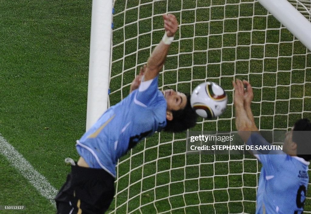 Uruguay's striker Luis Suarez (R) stops