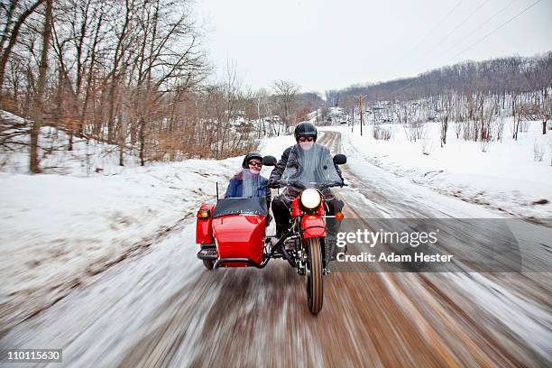 an adult couple riding a motorcycle. - motorbike sidecar stock pictures, royalty-free photos & images