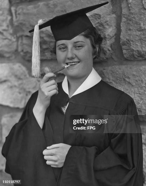 Young graduate of the University of Kansas smokes a pipe of peace - part of the traditional commencement exercises, circa 1945.