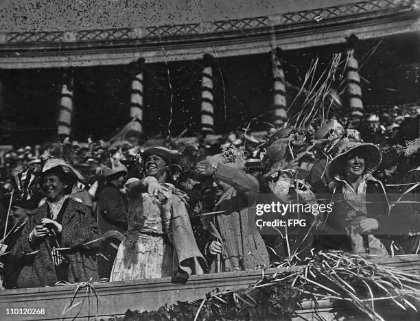 Women throw confetti during a Harvard University commencement ceremony, Harvard Stadium, circa 1915. . This image has been digitally retouched.