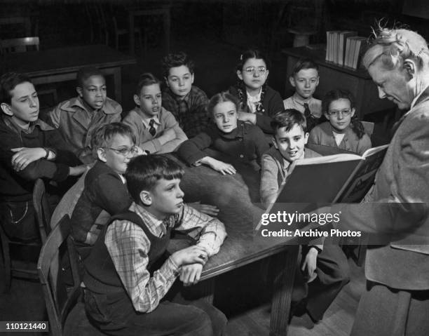 Library teacher giving a class to a group of boys and girls at a New York City public school, circa 1950.