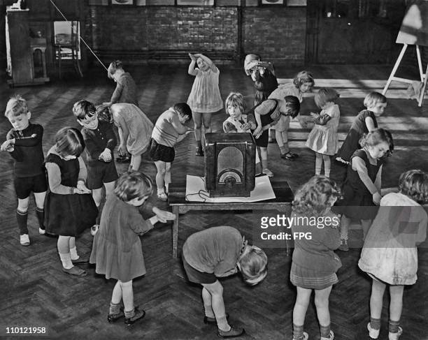 Primary school children performing their own actions to go with a BBC 'Music And Movement' programme on the radio, London, circa 1935.