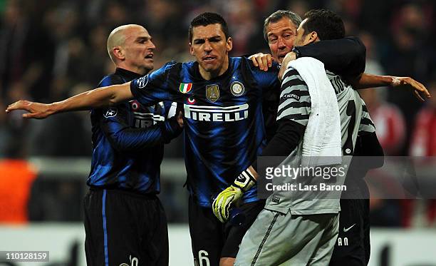 Lucio of Milan celebrates with team mates Esteban Cambiasso and goalkeeper Julio Cesar after winning the UEFA Champions League round of 16 second leg...