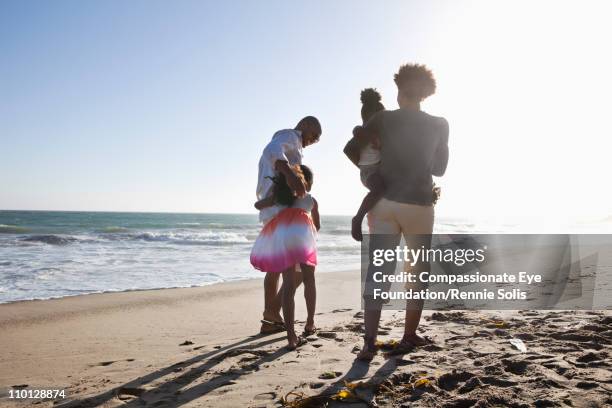 family walking down the beach together - beach la stock pictures, royalty-free photos & images