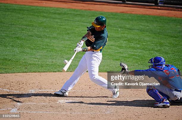Hideki Matsui of the Oakland Athletics swings the bat against the Chicago Cubs during the spring training baseball game at Phoenix Municipal Stadium...