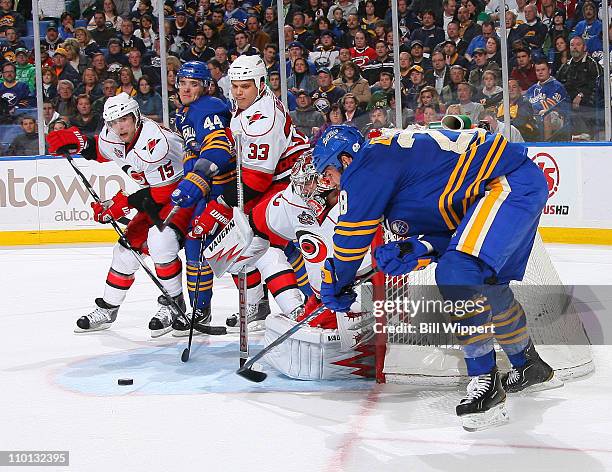 Cam Ward of the Carolina Hurricanes makes a save against Paul Gaustad of the Buffalo Sabres as Andrej Sekera of the Sabres is blocked by Tuomo Ruutu...