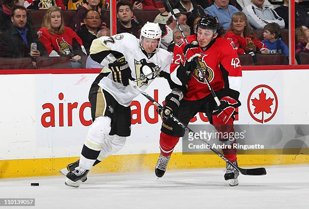 Jim O'Brien of the Ottawa Senators tries to skate by Paul Martin of the Pittsburgh Penguins with the puck at Scotiabank Place on March 15, 2011 in...