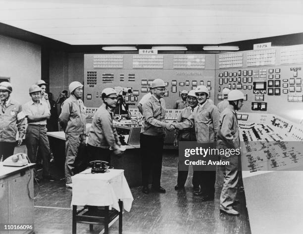 Robert Jeans , Vice-President of the US Westinghouse Electric Company, shakes hands with Hiromi Kato, of the Kansai Electric Power Company, at the...