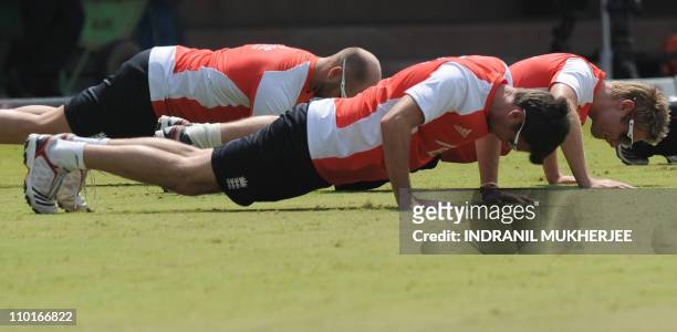England cricketers Matt Prior, James Anderson and Luke Wright perform push-ups during a training session at the M.A. Chidambaram Stadium in Chennai...