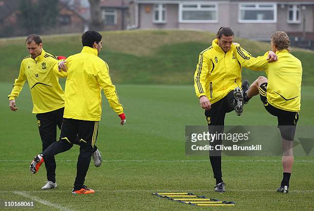 Liverpool forward Andy Carroll loosens up with team mate Dirk Kuyt, Milan Jovanovic and Louis Suarez also loosen up during a training session ahead...