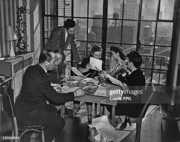 Editorial staff in a meeting to decide the layout for 'Whisper' magazine circa 1950.