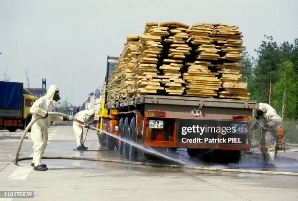 West German customs officials hose down a lorry with water they are closely screening goods, cars and people coming in from Eastern Europe, where...