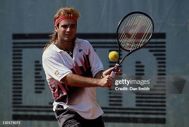 Andre Agassi of the United States makes a double hand return against Andres Gomez during the Men's Singles final match during the French Open Tennis...